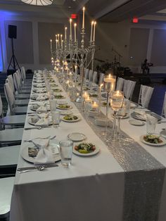 a long table is set up with plates and silverware for an elegant dinner party