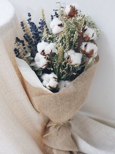 a bouquet of cotton flowers wrapped in burlock