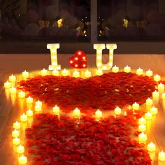 candles are arranged in the shape of hearts and i love you letters on a table