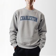 Explore the timeless charm of Charleston in our Charleston, SC, Collegiate Crewneck Sweatshirt. This classic sweatshirt, crafted from a durable polyester and cotton blend, offers comfort and style for strolling down cobblestone streets or exploring historic homes. The fabric ensures you stay warm on chilly evenings by the harbor or cool mornings at the farmers' market. With a ribbed knit collar that retains its shape and elasticity, this sweatshirt is designed to last. The seamless, tubular knit Sophisticated Lifestyle, Varsity Crewneck, Southern Elegance, Seamless Knitting, Cobblestone Streets, Hometown Pride, Classic Sweatshirt, Casual Night Out, Historic District