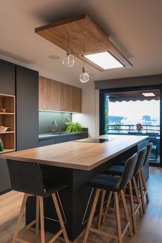 a kitchen with an island and bar stools in front of the countertop area