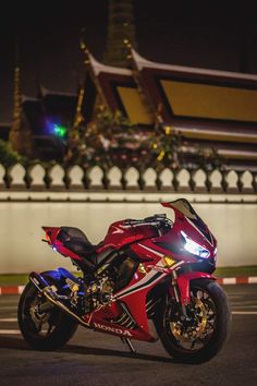 a red motorcycle parked on the street at night