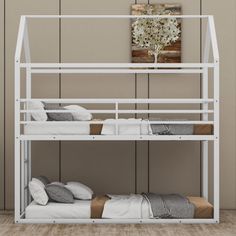 a white bunk bed sitting next to a wooden wall with a plant on top of it