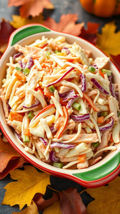 a bowl filled with coleslaw and carrots on top of leaves