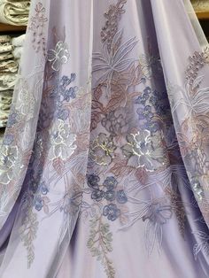 the back of a woman's dress with flowers and leaves on it in purple