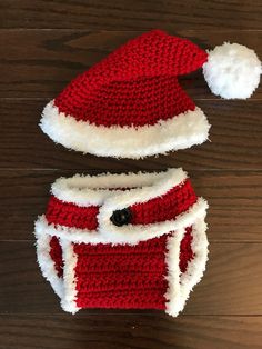 a crocheted santa hat and diaper cover sitting on top of a wooden table