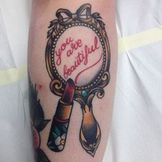 a person with a tattoo on their arm that says you're beautiful and there is a magnifying glass in the middle