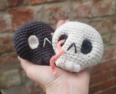 two crocheted stuffed animals in the palm of a person's hand, one with a nose