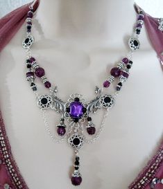 "This beautiful necklace has black glass beads, pewter silver accent beads, purple faceted beads, pewter silver bead caps, seed beads, silver plated bead caps, pewter silver rhinestone accents, metal chain, silver plated filigree pendant with purple faceted glass setting and rhinestones. It can be worn as a choker or adjusted up to 20\" long. Lobster clasp." Gothic Purple Metal Jewelry, Gothic Black Amethyst Jewelry, Gothic Purple Jewelry For Formal Occasions, Ornate Handmade Purple Jewelry, Purple Gothic Jewelry For Formal Occasions, Elegant Purple Jewelry With Silver Beads, Gothic Silver Beaded Jewelry, Silver Gothic Beaded Jewelry, Gothic Silver Jewelry With Round Beads