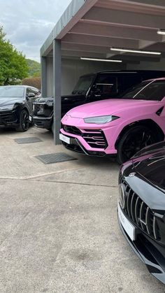 several cars parked in a parking lot with pink and black paint on the hoods