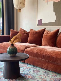 a living room filled with furniture and a large painting hanging on the wall above it