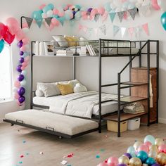 a bunk bed with a futon underneath it and lots of balloons on the wall