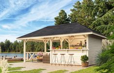 a gazebo with two bar stools in front of it and a boat on the water