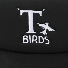 Rock a classic look with this black Grease trucker hat featuring the iconic T-Birds logo. With gray mesh on the sides and back, this hat combines style and comfort seamlessly. Made from durable polyester, it comes with an adjustable snapback closure, ensuring a perfect fit. Hand wash it in cold water and lay it flat to dry for easy care. This officially licensed Grease accessory brings authenticity and style to your wardrobe. Elevate your fashion game with this timeless T-Birds trucker hat. Black Trucker Hat With Letter Print And Flat Bill, Black 5-panel Hat With Letter Print, Black 5-panel Snapback Hat With Letter Print, Black 5-panel Trucker Hat With Embroidered Logo, Black Trucker Hat With Letter Print And Curved Brim, Black Embroidered Logo 5-panel Trucker Hat, Black Trucker Hat With Letter Print For Outdoor, Black 5-panel Trucker Hat With Letter Print, Black Letter Print Snapback Trucker Hat