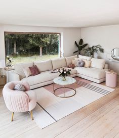 a living room filled with furniture next to a large window covered in plants and greenery