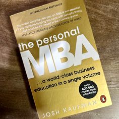 a book about the personal mba by joshua kaupman on a wooden table top