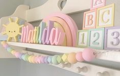 there is a shelf with letters and numbers on it in pastel colors, such as rainbows