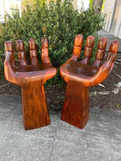 two wooden chairs made to look like hands