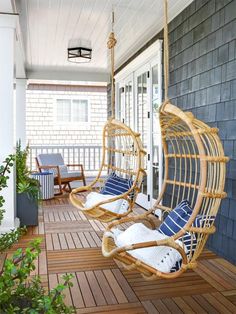 a wooden porch with two hanging chairs on it