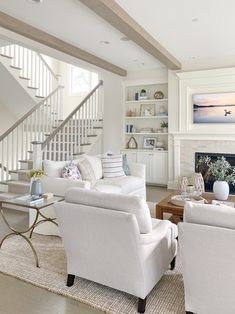 a living room filled with furniture and a fire place in front of a stair case