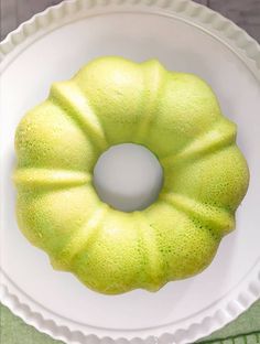 a cake sitting on top of a white plate next to a blue and green sign