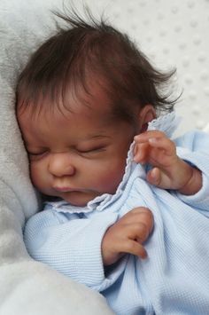 a small baby wrapped in a blue blanket