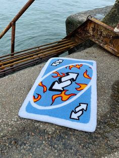 a towel is laying on the ground next to some stairs and water with a boat in the background