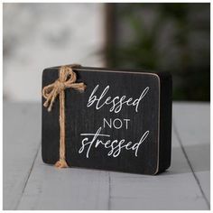 Dimensions: 2.94" H x 3.88" W x 1" D Material: MDF Shape: Rectangle Color: Black, White & Natural Orientation: Horizontal Quantity: 1 Remind yourself to live life simply with this Blessed Not Stressed Wood Decor. This MDF block is painted black with a string of jute tied around one side to form a cute little bow. The block has the phrase "Blessed Not Stressed" written in white text to remind yourself to stay highly favored instead of strained and tired. Keep this piece around to remind yourself Living Room Christian Decor, Scripture Decor, Highly Favored, Wood Block Crafts, Mini Signs, Bazaar Ideas, Christian Crafts, Dollar Tree Finds, Block Craft