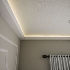 an empty room with a radiator and light fixture on the ceiling above it