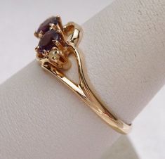 This is a very old piece! This ring has 2 synthetic purple stones that measure 4 mm each. The stones are both older cut and one is more purple-y colored than the other. The ring also has 2 seed pearls that measure 1.5 mm each and are prong set. The ring is not stamped but has been tested and is 9 karat yellow gold. The ring weighs 1.9 grams and is a size 7.5. The inside does have a maker's mark stamped inside that says N W (with a circle around it) and W. Also just next to the stamp has been han Vintage Formal Three Stone Birthstone Ring, Formal Three Stone Amethyst Ring, Classic Three Stone Amethyst Ring For Anniversary, Classic Three Stone Amethyst Ring For Formal Occasions, Classic Three Stone Purple Jewelry, Vintage Ruby Ring For Anniversary, Classic Gift Amethyst Three Stone Ring, Classic Three Stone Amethyst Ring For Gift, Victorian Style Purple Ring In 14k Gold