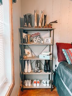 there is a shelf with shoes on it in the corner next to a bed and window