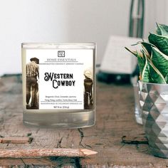 a candle sitting on top of a wooden table next to a potted plant