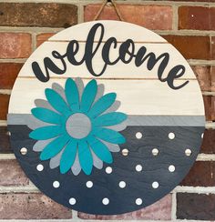 a welcome sign hanging on a brick wall