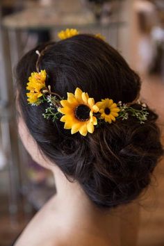 a woman with sunflowers in her hair is looking at the back of her head