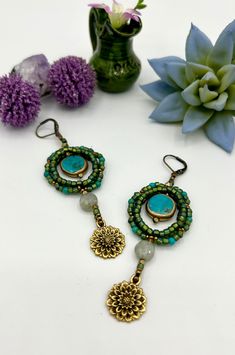 The hoop beads conjure a rich multi-colored green scene, with the way they reflect light. Onto that I added gorgeous Turquoise n gold coins, faceted Labradorite pillows, and golden lotus charms. The vibe is paz, coolness, and love.  The handbeaded earrings were made with no metal, and are somewhat flexible, and very lightweight. The Turquoise coin beads are edged with gold.  Measurements are: length 2 3/4 inches; hoop 1 inch across; lotus charm 1/2 inch across. One of a kind set. handbeaded with love in New Mexico. Green Bohemian Jewelry For Healing, Artisan Green Jewelry For Festival, Handmade Green Bohemian Jewelry, Green Spiritual Earrings With Natural Stones, Spiritual Green Earrings With Natural Stones, Green Spiritual Earrings For Healing, Bohemian Earrings With Spacer Beads As Gift, Bohemian Earrings With Spacer Beads For Gift, Green Beaded Dangle Earrings With Natural Stones