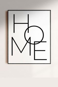 a black and white square with the word home on it's side, against a wall