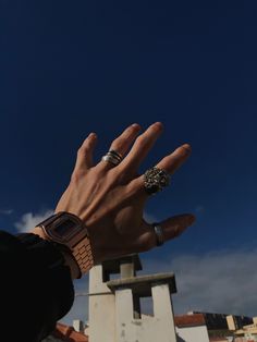 a person's hand reaching up into the air with two rings on their fingers