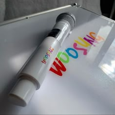 a microphone sitting on top of a table with the word wow written in rainbow letters