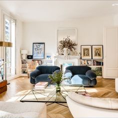 a living room filled with furniture and pictures on the wall