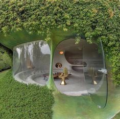 an unusual house that looks like it has been built into the ground and is surrounded by greenery