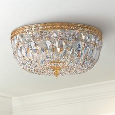 a crystal chandelier hanging from the ceiling in a room with white walls and trimmings