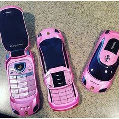 three pink cell phones sitting next to each other on top of a carpeted floor