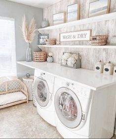 a washer and dryer sitting in a room next to a shelf with pictures on it