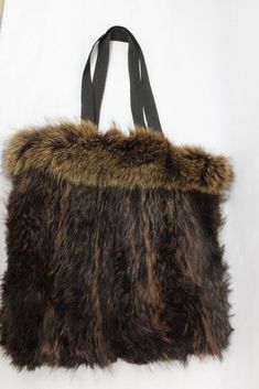 "RACCOON FUR TOTE STYLE BAG!  THIS ITEM IS SCRAP: THE FUR IS RIPPED BUT THE GOOD PART CAN BE USED FOR FUR ACCESSORY PROJECET! MEASUREMENT: SIZE 14\"(HEIGHT) X 14\"(WIDTH)  STRAP LENGTH: 22\" a10169 Oliverfurs 9250 Parc Ave. #204, Montreal, Quebec, H2N 1Z2, Canada www.oliverfurswholesale.com oliver@oliverfurswholesale.com Toll free: 1-866-845-9997 International: 1-514-845-9997" Faux Fur Lined Tote Bag, Shopping Bags With Faux Fur Lining, Brown Rectangular Bag With Faux Fur Lining, Brown Shopping Bag With Faux Fur Lining, Brown Bag With Faux Fur Lining For Shopping, Brown Faux Fur Lined Shoulder Bag, Everyday Tote Bag With Faux Fur Lining, Daily Use Tote Bag With Faux Fur Lining, Brown Shoulder Bag With Faux Fur Lining