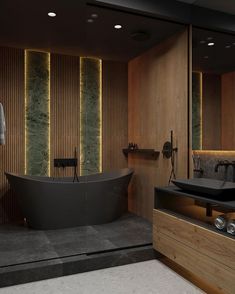 a bathroom with a large black bathtub next to a walk in shower