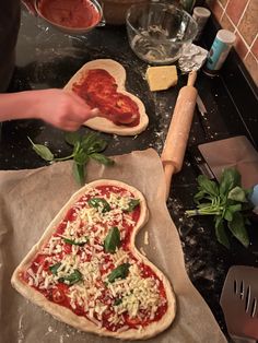 two pizzas are being made on the kitchen counter