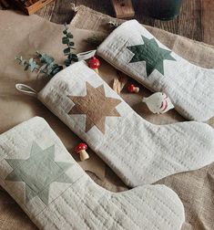 two decorative pillows with stars on them sitting on top of a cloth covered tablecloth