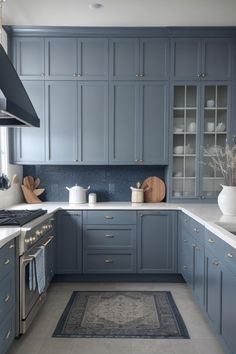 a kitchen with blue cabinets and white counter tops is pictured in this image, the area rug has been placed on the floor