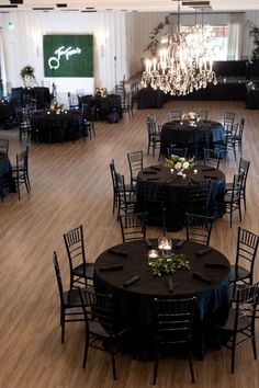 All black table scapes at the reception. Black chairs, black napkins, black table cloths Black Gala Decorations, Centerpieces On Black Tablecloths, Black Table Cover Wedding, Simple Wedding Centerpieces Black Tablecloth, All Black Wedding Centerpieces, Black Tables Weddings, Black Tablecloth Centerpiece Ideas, Black On Black Table Setting, Black Tablecloth Decor Wedding