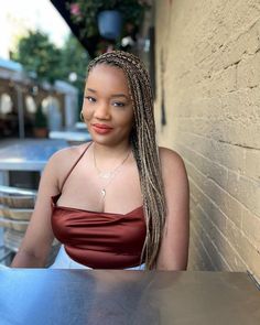 a woman with long braids sitting at a table